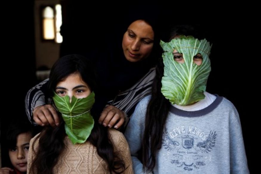 two people wearing cabbage leaves as face masks